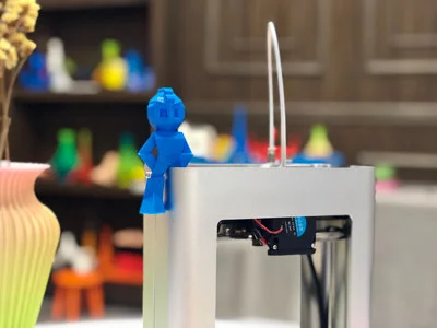 3D Printer with Blue Figure