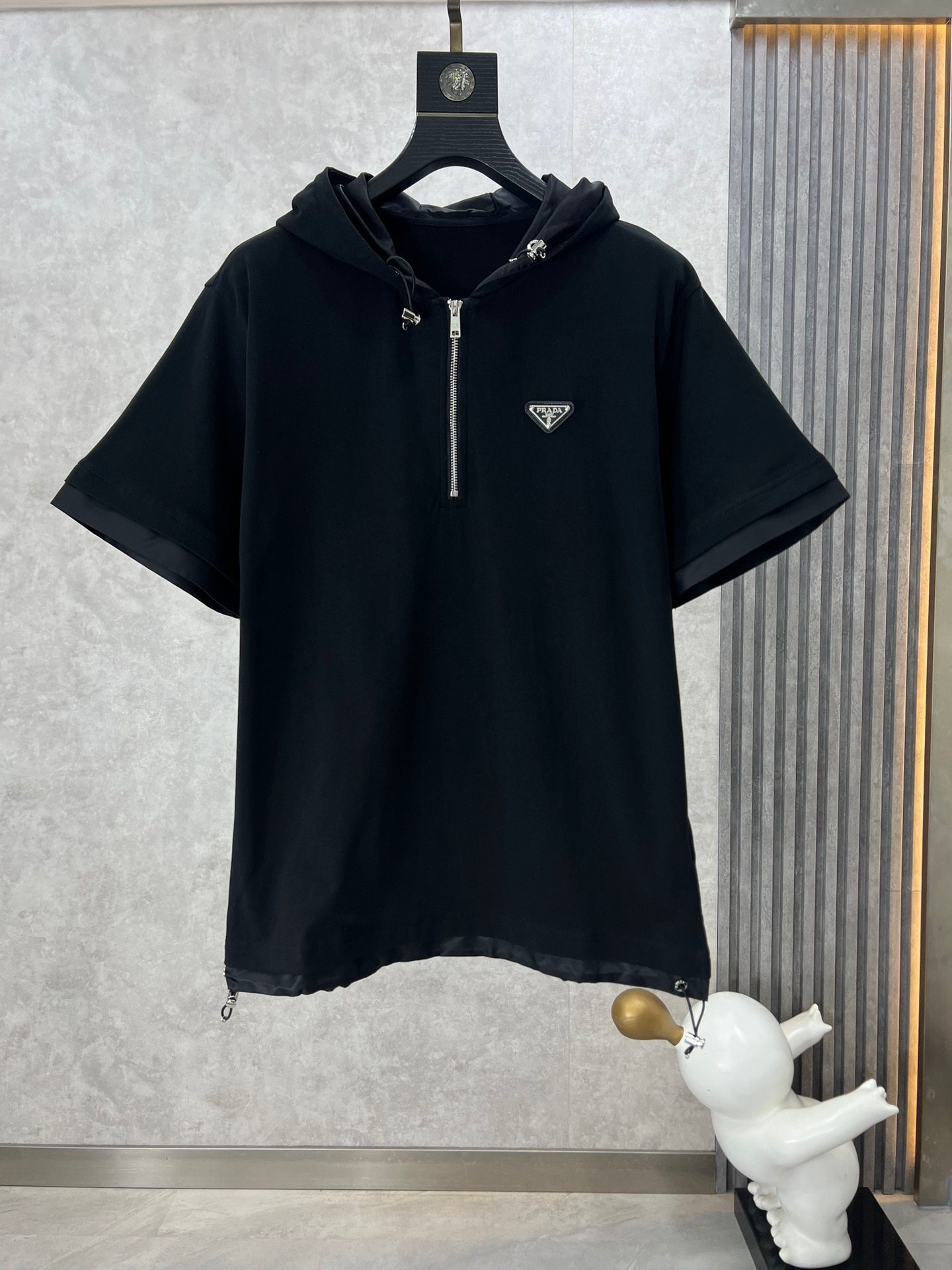 The 2024 SS spring and summer new hooded nylon spliced T-shirt from P. This T-shirt combines sporty minimalist design and exquisite details. It is spliced with P's exclusive parachute nylon fabric, and the Pra enamel-coated triangular metal emblem on the front chest is full of historical heritage.e